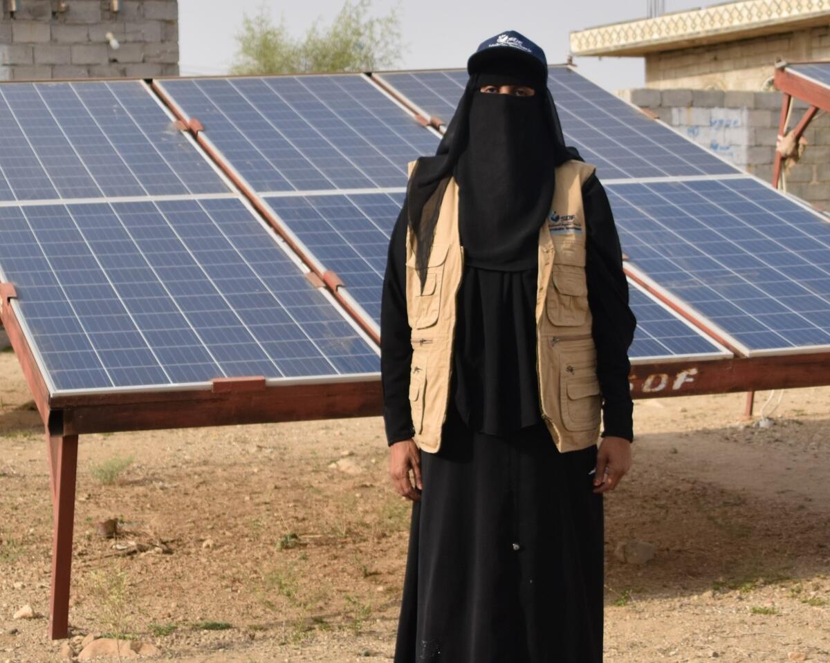 Yemen. Eman stands next to her solar system project.