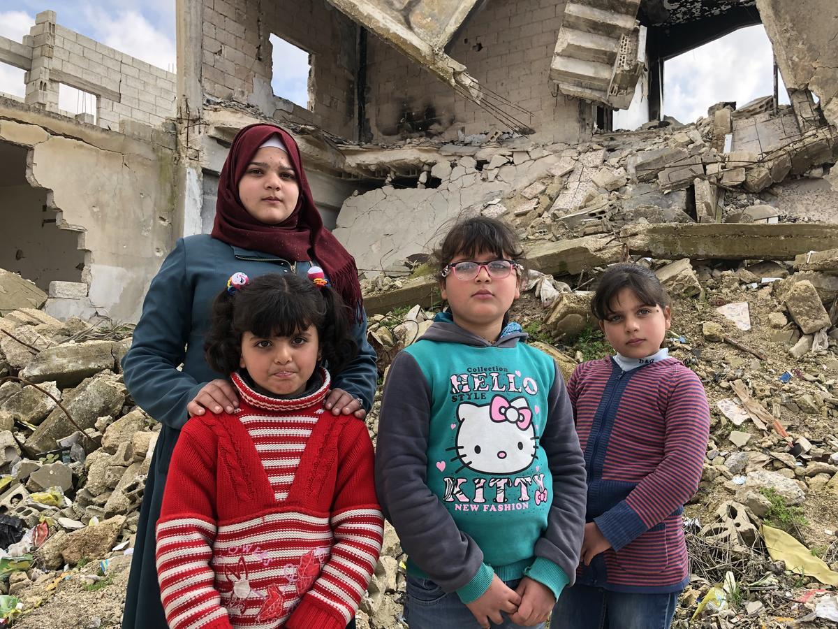 Zahida's four daughters pose by the ruins of their home in Souran, Syria. 