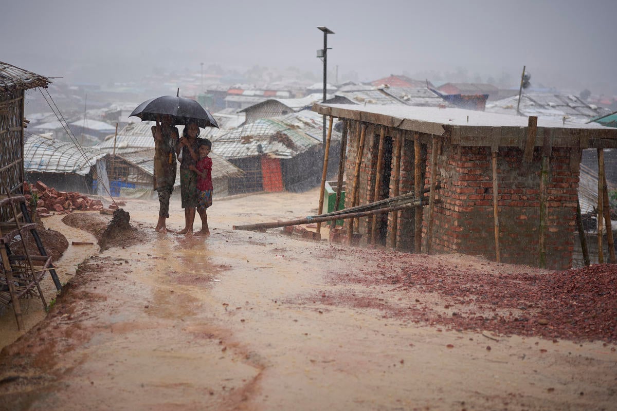 Bangladesh. Rohingya refugees walk through a heavy monsoon downpour
