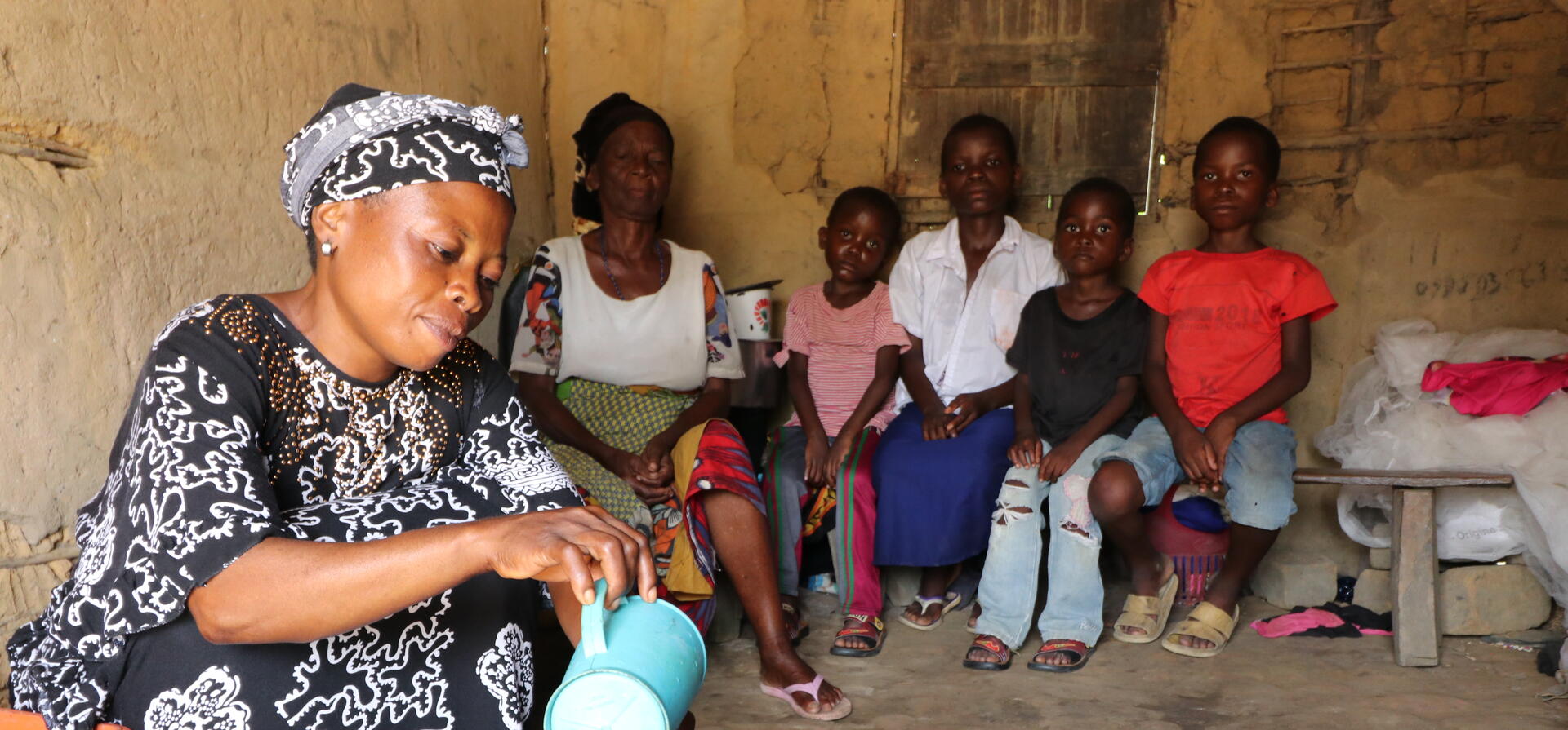 "When I met these children, they were very sad and traumatised. They needed a place to call home more than anything else. I could not leave them on their own."

Justine Mbilizi, 39, from the host community in Kitutu, South Kivu, pours palm wine into recycled glass bottles. She brewed it to sell to neighbours. Justine lives with her mother, husband and five children and has taken in four displaced children whose mother died during childbirth. Their father is desperately searching for work.