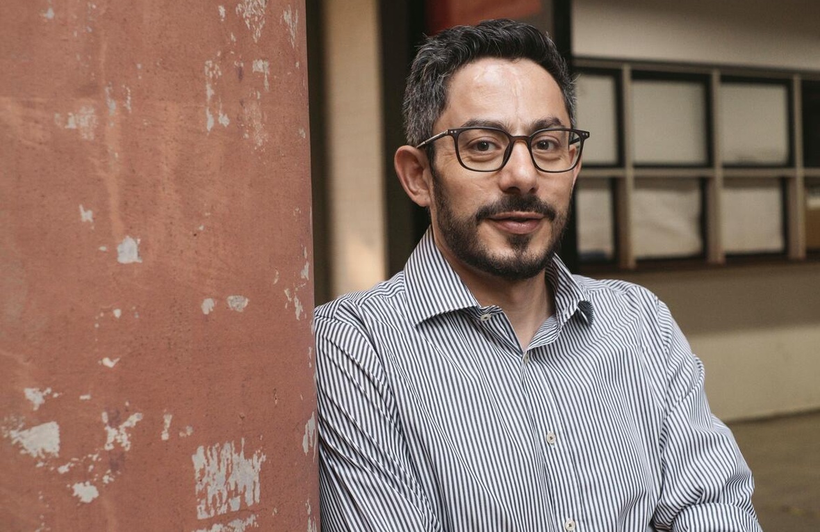 Syrian refugee Anas Abdulrjab poses for the camera, leaning against a wall.