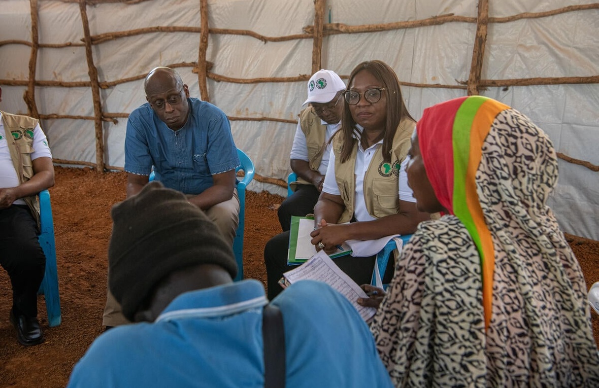 A group of people having a discussion inside a huge shelter