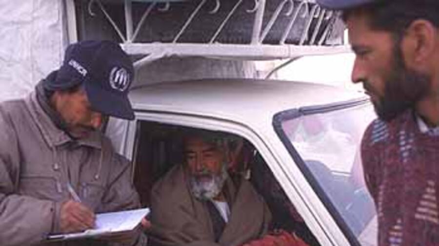 UNHCR staff verify internally displaced persons at a military checkpoint in Kabul.