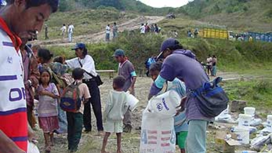 East Timorese refugees receive supplies as they return through the Lakhmaras ridge in East Timor.