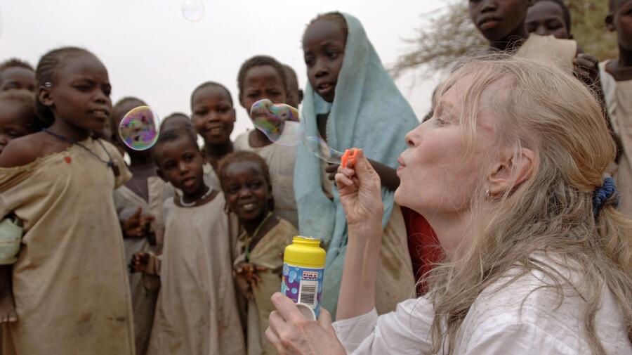 Actress and UNICEF Goodwill Ambassador Mia Farrow blows soap bubbles to the delight of children at the Zam Zam camp for people displaced by the conflict in Darfur.