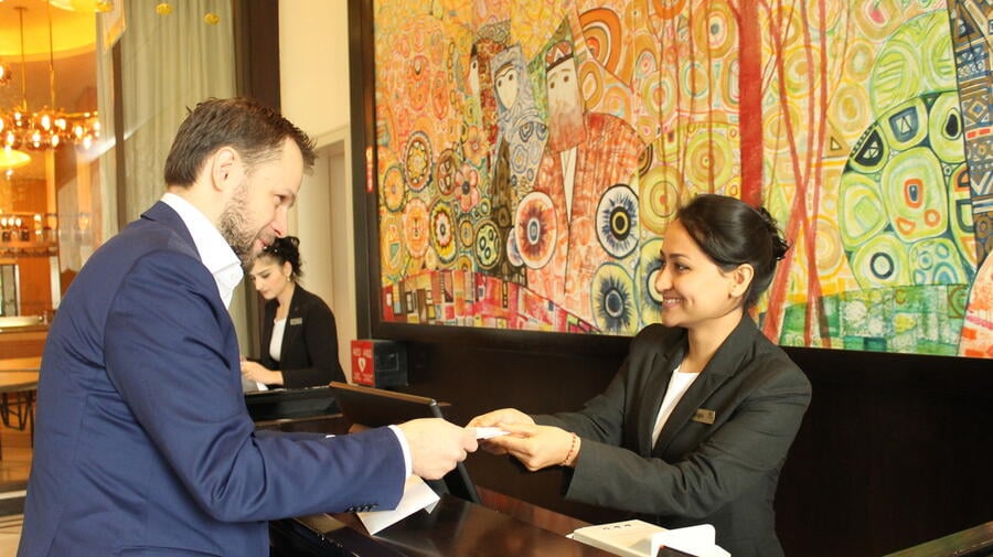 Tajikistan. Afghan refugee Nargis, confidently receiving a guest at the Front Desk, during the Apprenticeship Programme at the renown Sheraton Hotel in Dushanbe