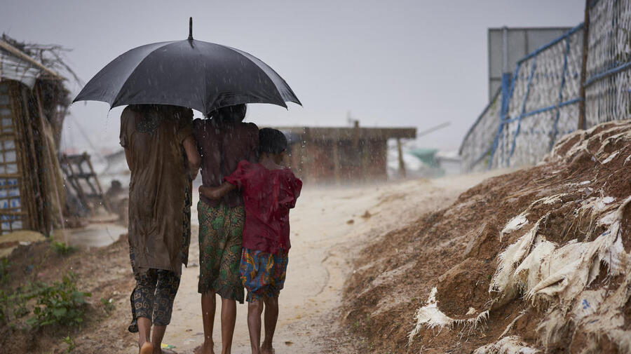 Bangladesh. Rohingya refugees walk through a heavy downpour