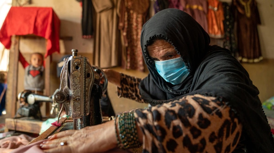 An internally displaced woman living in Jalalabad city in Nangarhar Province works on a garment she is sewing for a customer