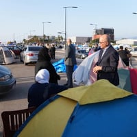 Barham Salih, Hoge Commissaris van de VN voor Vluchtelingen (midden), spreekt met Libanese gezinnen die binnen het land ontheemd zijn geraakt, in Beiroet.