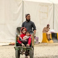 Hadigul porte ses jeunes sœurs, Sabria et Freshta, alors qu’ils voyagent ensemble après leur récent retour en Afghanistan. Malgré les épreuves qu’ils ont traversées, cette famille très unie fait preuve de résilience et de force pour aller de l’avant.