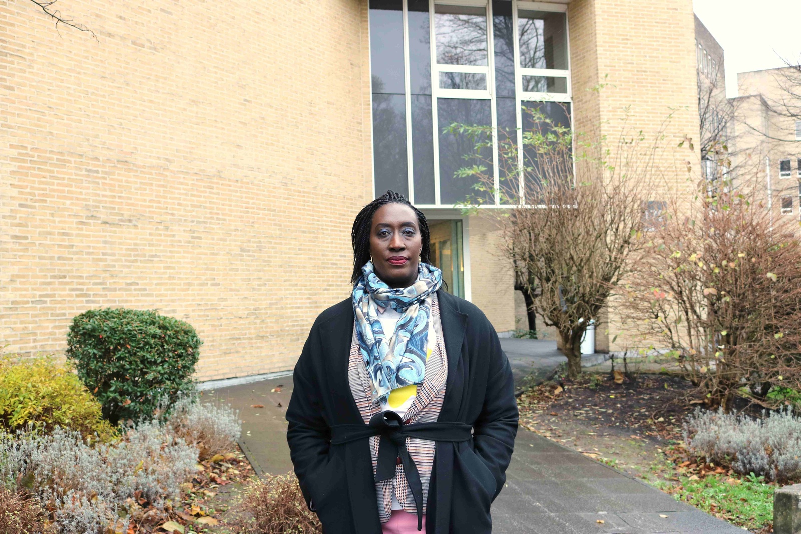 Doris, former Burundian refugee and now manager of the Triomphe shelter, stands in front of the former office building now hosting asylum-seekers left homeless on the streets.