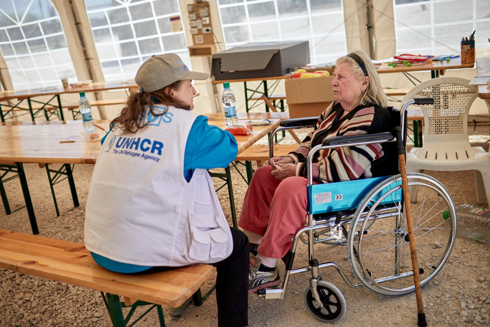 Svetlana, 83 ans, est réconfortée par le personnel partenaire du HCR dans une zone de repos à Palanca, en Moldavie. © HCR/Andrew McConnell