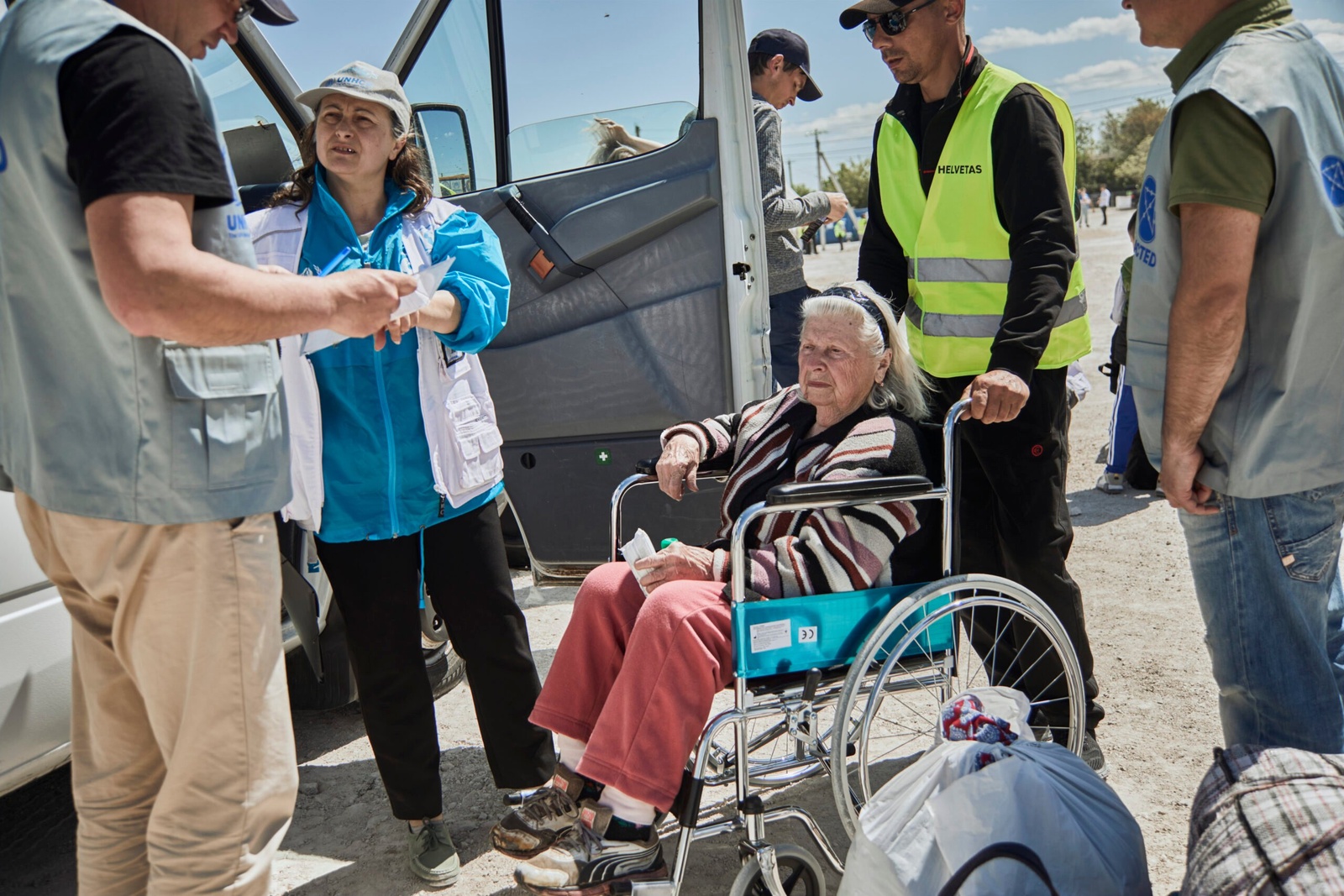 Des membres du personnel d'organisations partenaires du HCR aident Svetlana, 83 ans, lors de son arrivée depuis l'Ukraine au poste frontière de Palanca en Moldavie. © HCR/Andrew McConnell