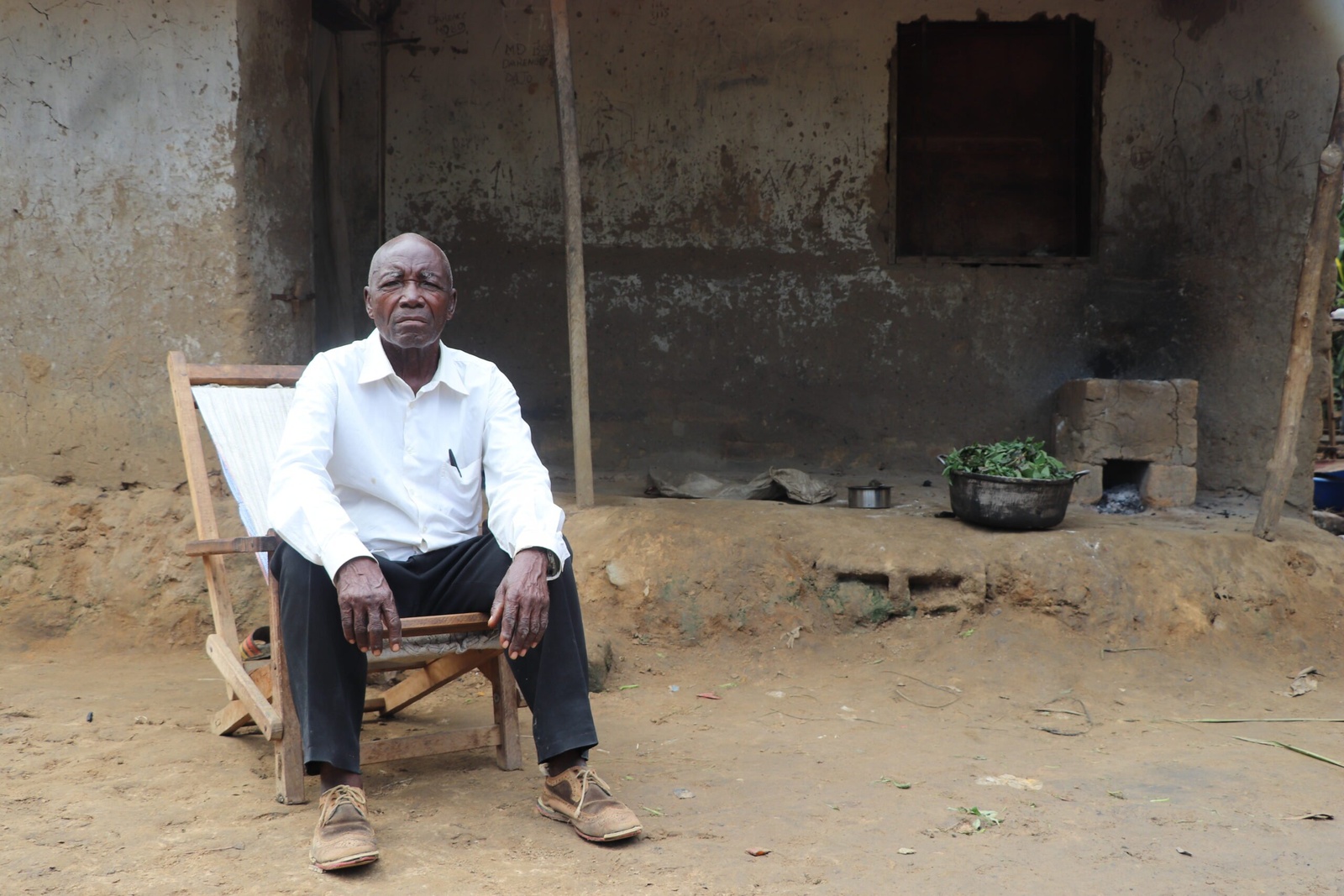 Emmanuel Nyama Numa a 87 ans. Il a fait une carrière d’infirmier à Kinshasa. Il est devant sa maison. Depuis que les personnes déplacées de Mi Ndombe sont arrivées à Bandundu, il a accueilli 29 d’entre elles, surtout des femmes et des enfants. © HCR/Simon Lubuku