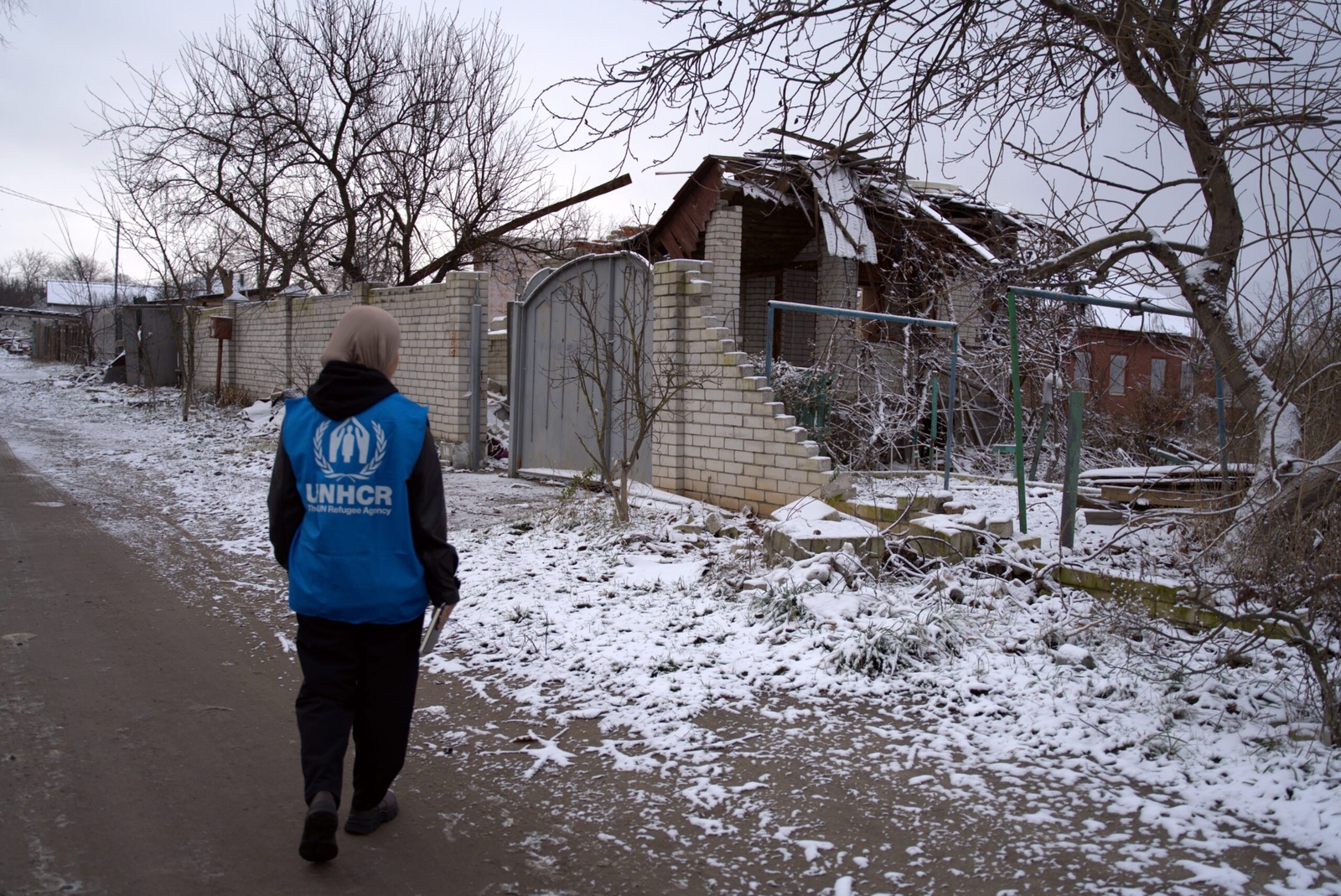 Een UNHCR-werknemer kijkt naar de schade door de bombardementen. © UNHCR/Victoria Andrievska