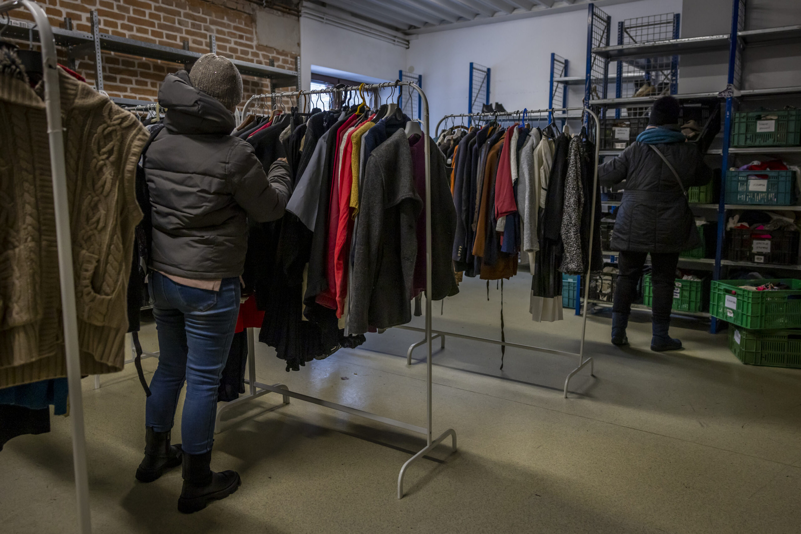 Een vluchtelinge snuistert door de rekken in het "Lagiewnicka Point", waar vluchtelingen onbeperkt terecht kunnen voor gratis kledij, huisraad, speelgoed en voedselpakketten. © UNHCR/Anna Liminowicz