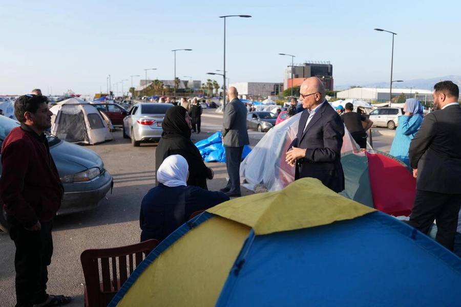 Barham Salih, Hoge Commissaris van de VN voor Vluchtelingen (midden), spreekt met Libanese gezinnen die binnen het land ontheemd zijn geraakt, in Beiroet.