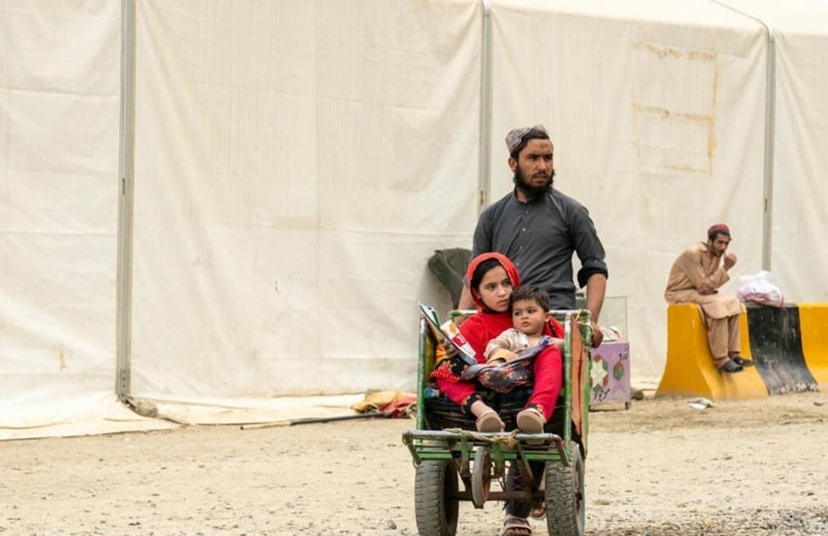 Hadigul porte ses jeunes sœurs, Sabria et Freshta, alors qu’ils voyagent ensemble après leur récent retour en Afghanistan. Malgré les épreuves qu’ils ont traversées, cette famille très unie fait preuve de résilience et de force pour aller de l’avant.