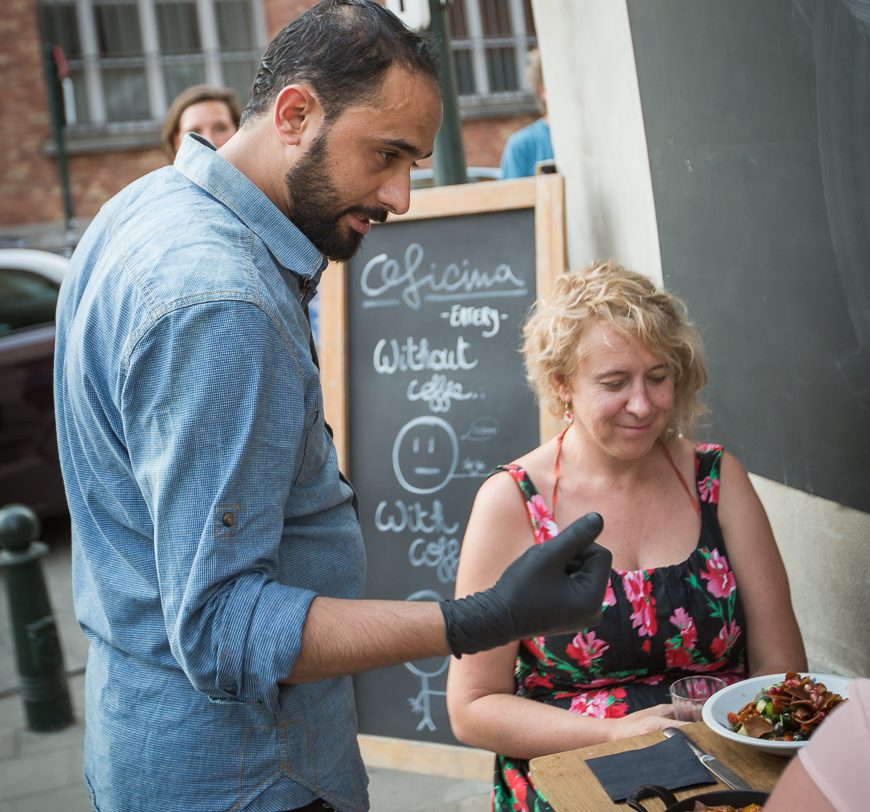 Refugee Chef Abdelbasset explains to customers_OFICINA-8247©Bea Uhart@UNHCR