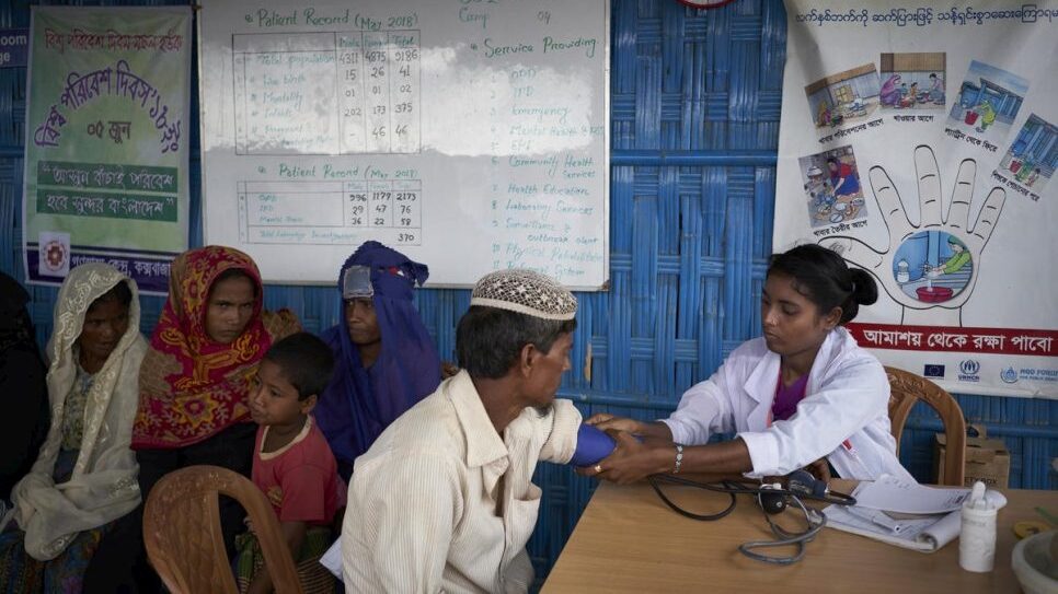 Een dokter controleert de bloeddruk van een Rohingya-vluchteling bij een UNHCR-kliniek voor primaire gezondheidszorg in het Kutupalong-vluchtelingenkamp, Bangladesh, juni 2018. © UNHCR/David Azia