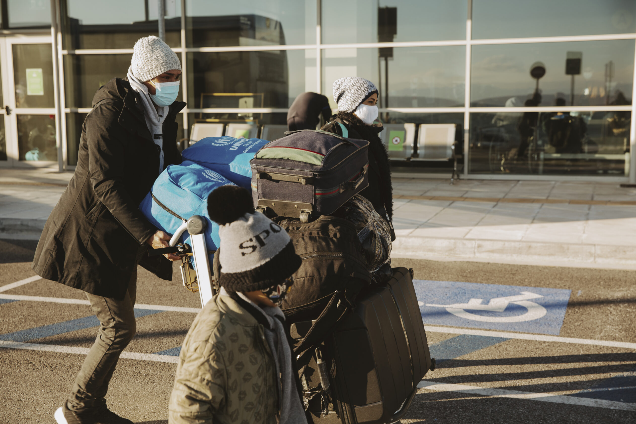 Une famille de réfugiés afghans se dirige vers la zone des départs de l'aéroport de Mytilène.