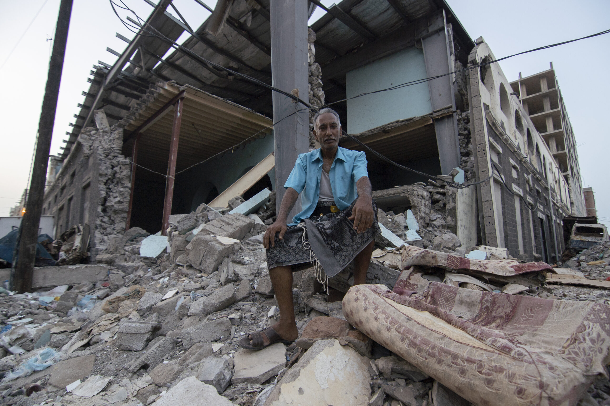 De 52-jarige Shaker Ali zit voor wat vroeger een marktplaats was in Aden, Jemen. © UNHCR/Saleh Bahulais