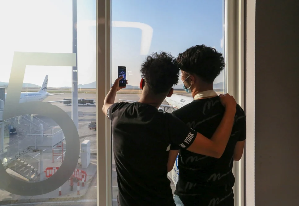 Deux enfants réfugiés font un selfie à l'aéroport d'Athènes avant leur vol de relocalisation vers la France. © OIM