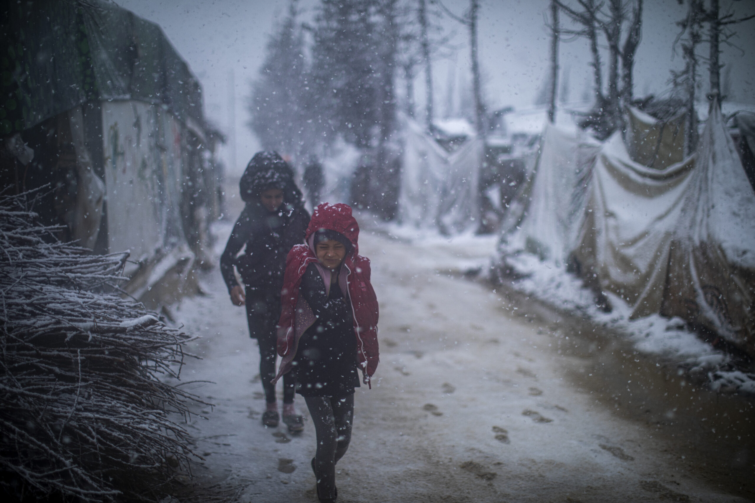 Jonge Syrische vluchtelingen lopen tijdens een zware storm door de sneeuw naar huis. In het informele vluchtelingekamp van de Bekavallei zijn de onderkomens niet geschikt om de barre wintermaanden te doorstaan. ©UNHCR/Diego Ibarra Sánchez