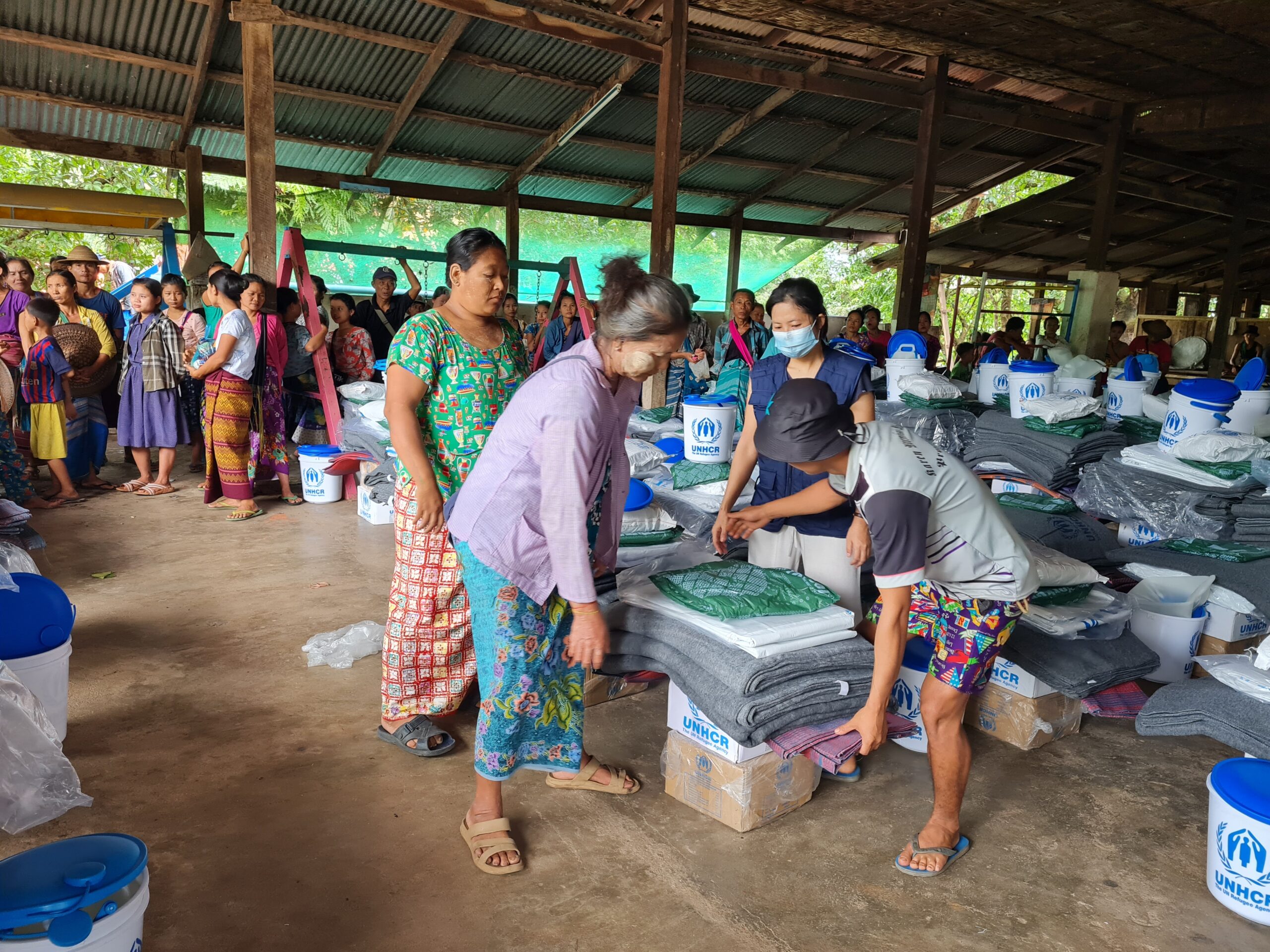 Binnenlands ontheemden ontvangen hulp in kamp Myaing Gyi Ngu in de staat Kayin in Myanmar, juni 2021. © UNHCR/Sa Nyein Chan