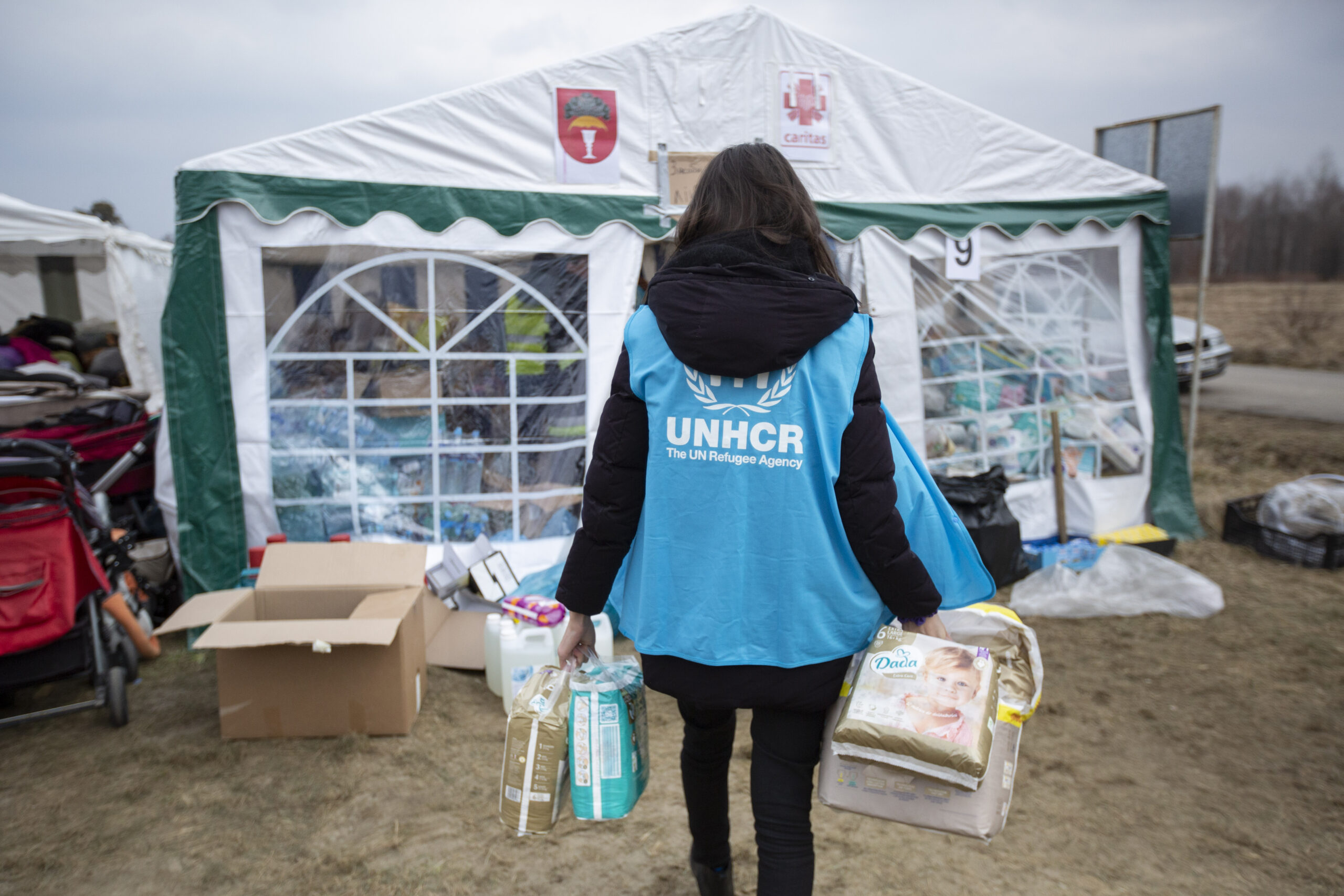 Een UNHCR-medewerker verzamelt luiers, voedsel, hygiëneproducten en andere zaken die door vrijgevige donoren zijn geschonken bij de grensovergang Budomierz in Polen. ©UNHCR/Valerio Muscella