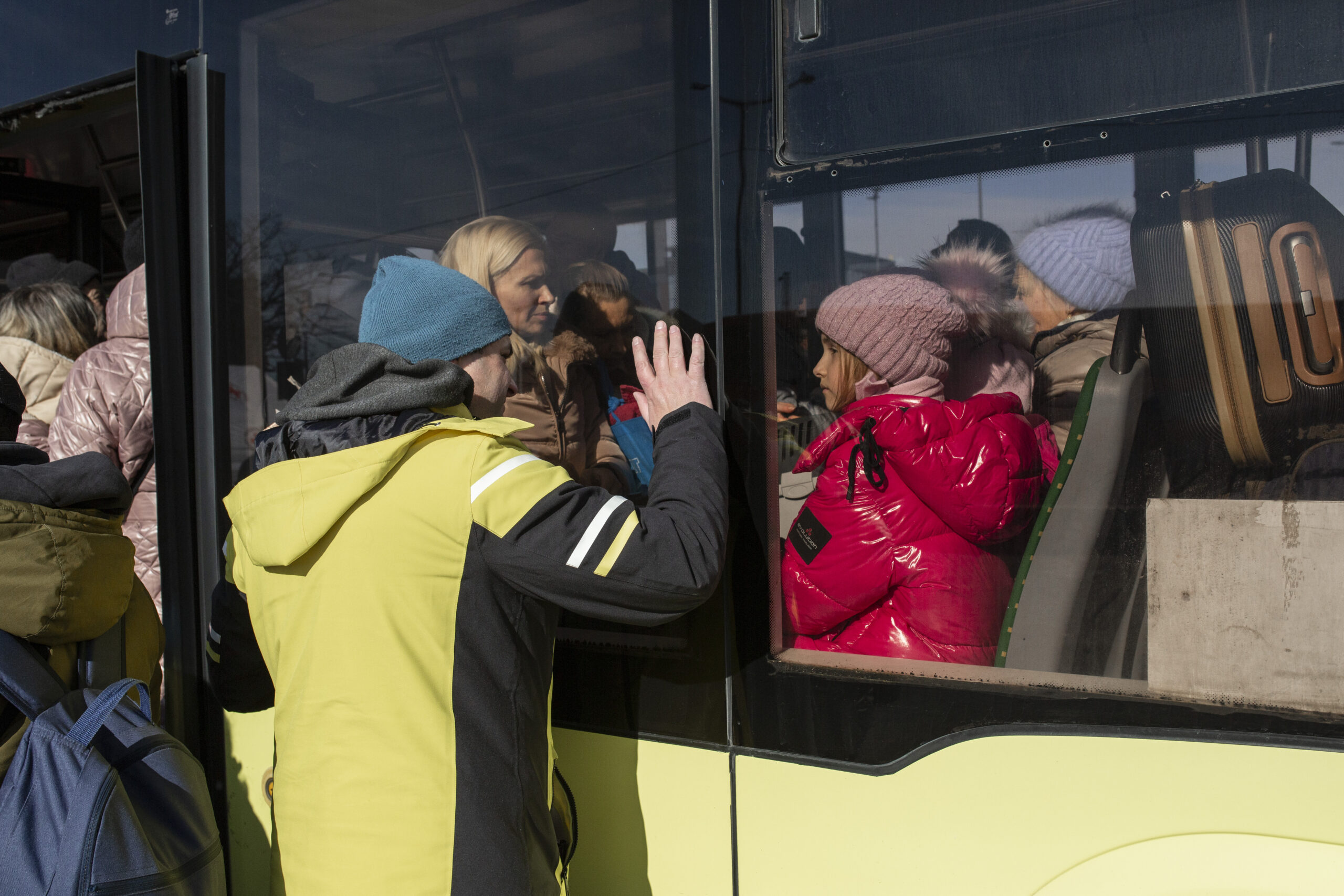 Un père fait ses adieux à sa famille à la gare routière de Lviv, dans l’ouest de l’Ukraine, alors que celle-ci part en quête de sécurité. © HCR/Valerio Muscella