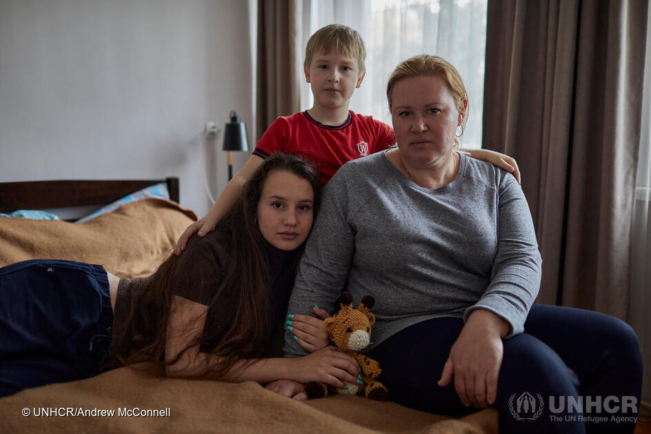 Daria avec sa mère Olga, 42 ans, et son jeune frère Sergey, 7 ans, dans la chambre de leur logement.