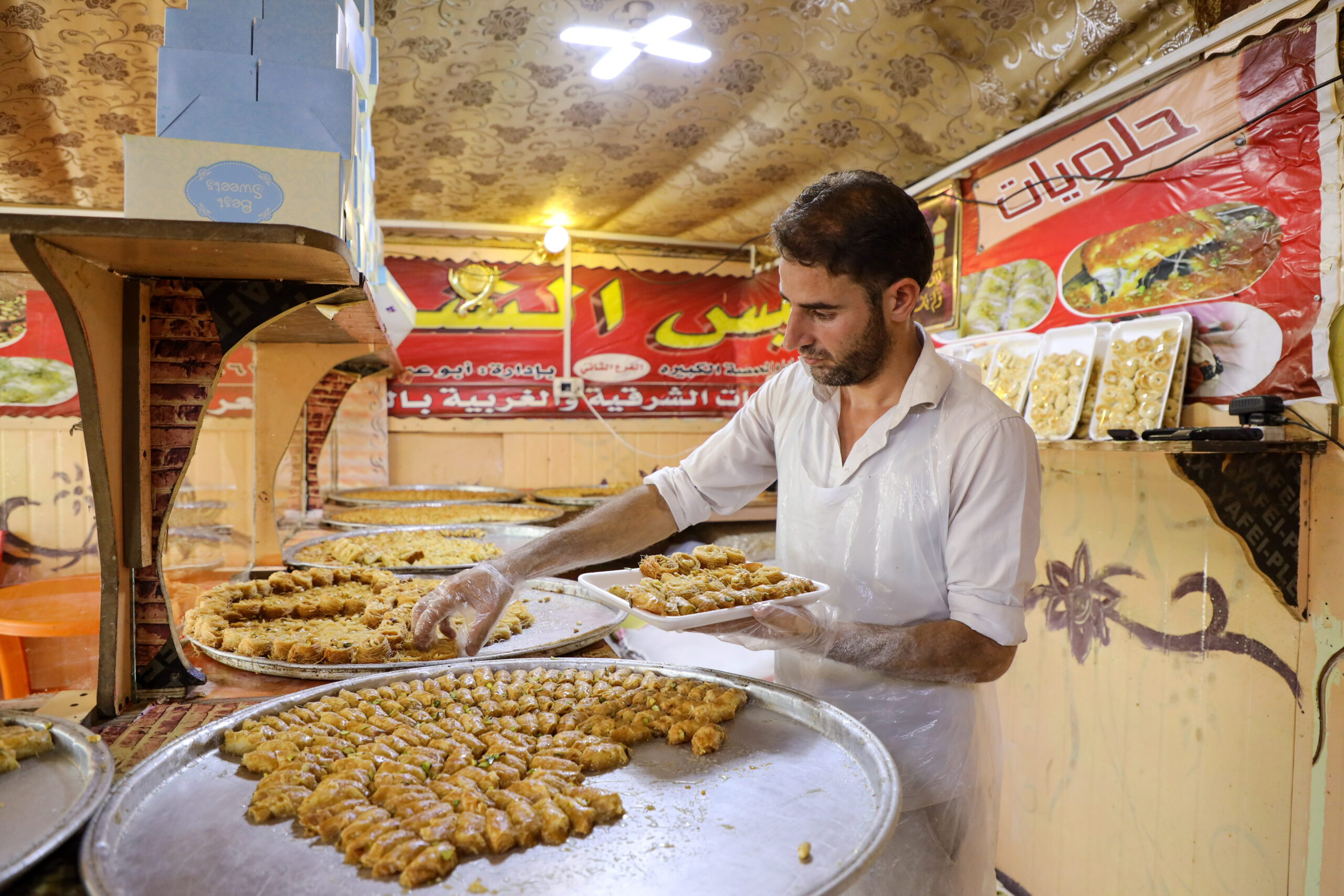 Odai, 28 jaar, die sinds 2012 in het kamp woont, verkoopt traditionele Arabische gebakjes. © UNHCR/Yousef Alhariri