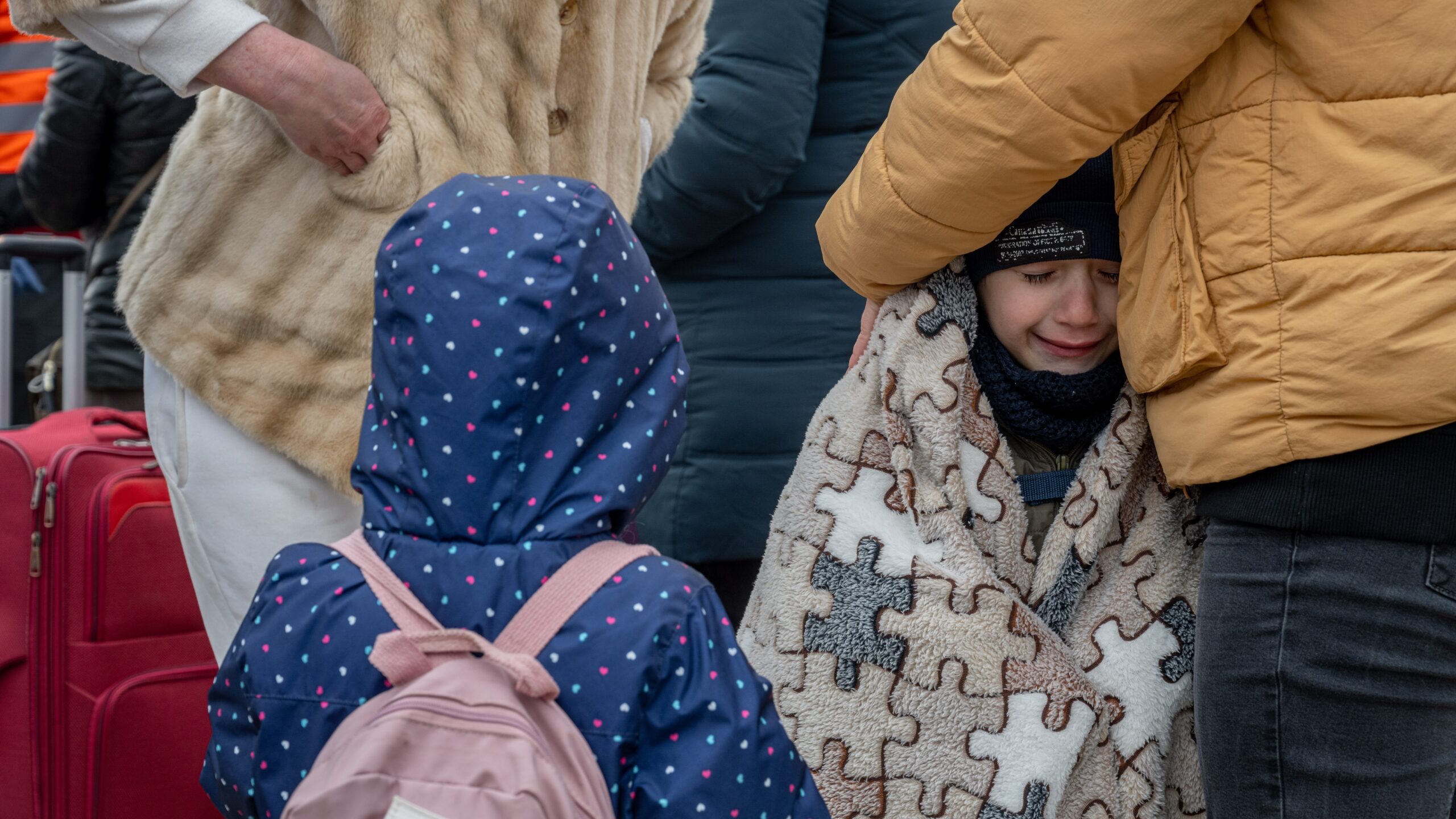 Moeder probeert kinderen warm te houden bij grensoversteek aan de Moldavische grens, maart 2022. © UNHCR/Mihai von Eremia