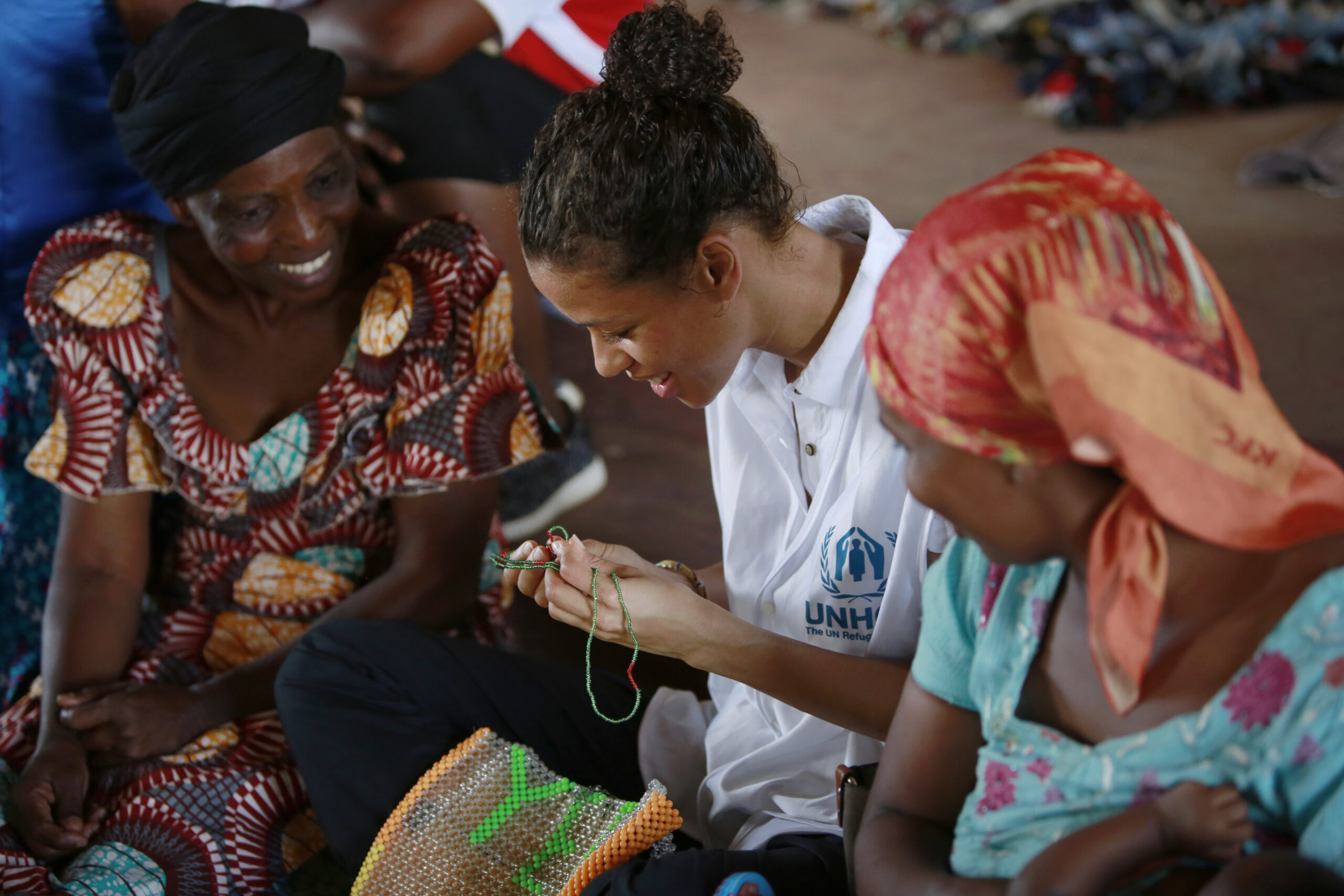 Britse actrice en Goodwill Ambassadeur Gugu Mbatha-Raw bekijkt het handwerk van vluchtelingenvrouwen in het centrum voor vrouwen in de Nakivale vluchtelingennederzetting in Oeganda, 2019. © UNHCR/Caroline Irby