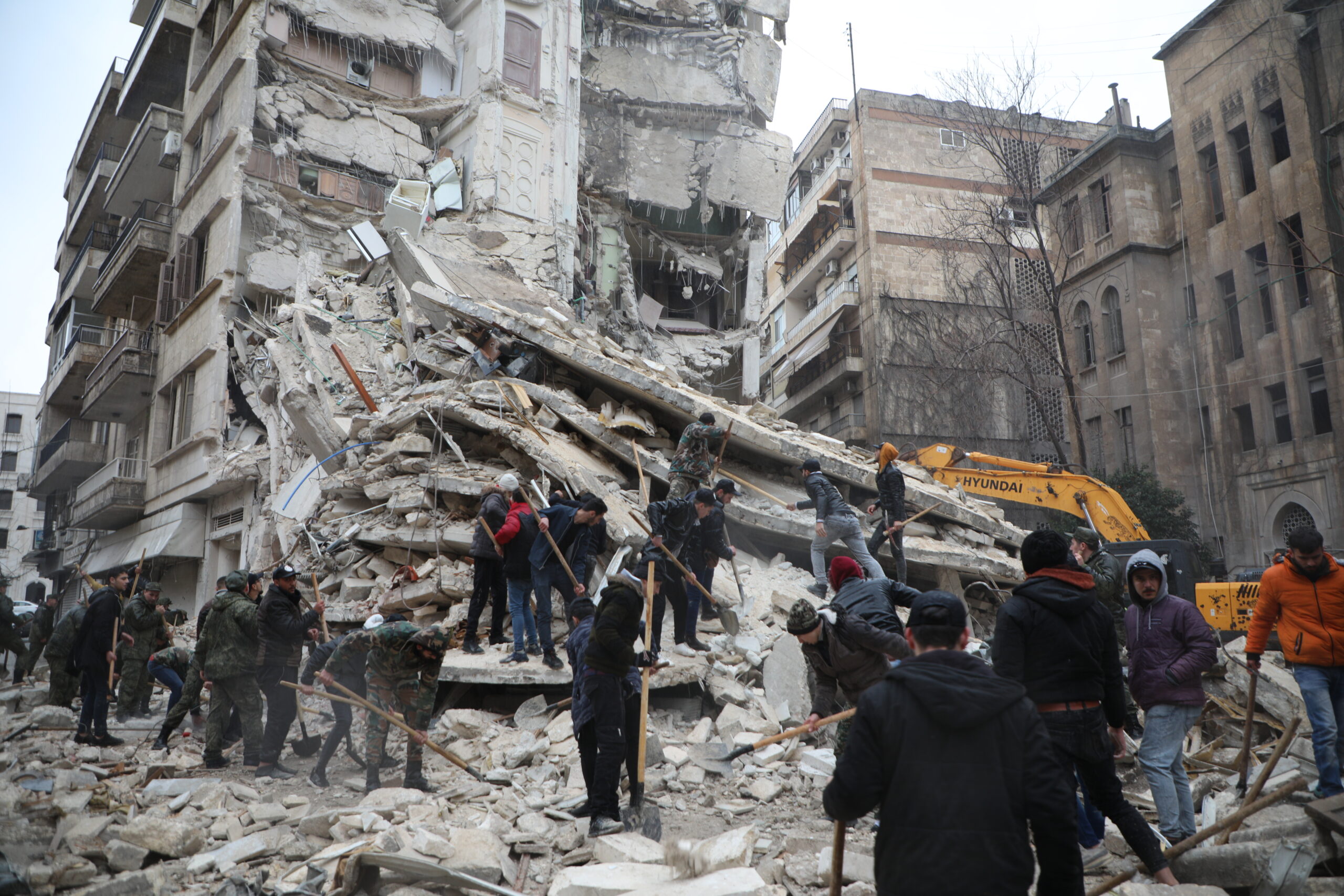 Mensen zoeken naar overlevenden onder het puin van een ingestort gebouw in de wijk Al-Aziziyeh in Aleppo, Syrië, na twee krachtige aardbevingen die de regio op 6 februari troffen.