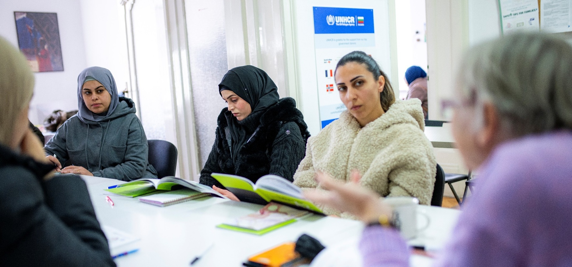 Refugee women listening to teacher