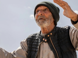 جاسم، أحد العائدين السوريين، يقف بالقرب من أنقاض منزله السابق في ريف القصير، محافظة حمص.