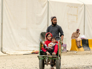 Hadigul porte ses jeunes sœurs, Sabria et Freshta, alors qu’ils voyagent ensemble après leur récent retour en Afghanistan. Malgré les épreuves qu’ils ont traversées, cette famille très unie fait preuve de résilience et de force pour aller de l’avant.