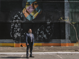 Abdul Jarour standing in front of a mural.