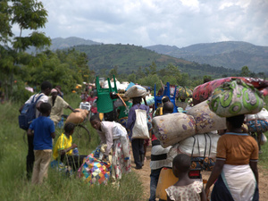 Congolese families walking with their belongings on their heads and backs