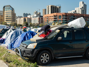 Tents and cars line Beirut's waterfront, sheltering displaced families.