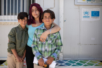 A woman and her two young sons, who are asylum-seekers from Syria, pose for a picture.