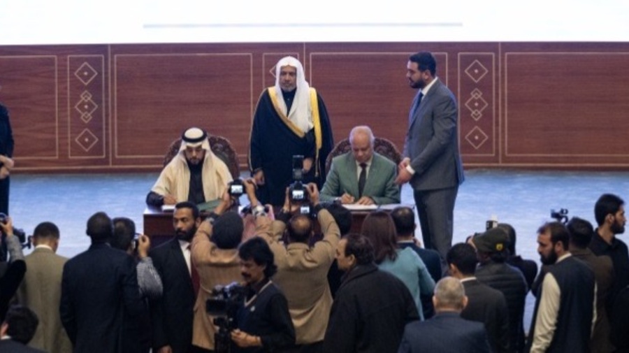  خالد خليفة، مستشار المفوض السامي وممثل المفوضية لدى دول مجلس التعاون الخليجي، وعبد الوهاب الشهري، مساعد الأمين العام للاتصال المؤسسي لدى رابطة العالم الإسلامي، أثناء توقيعهما على الاتفاقية. 