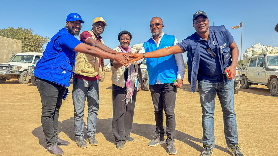 At a refugee settlement in Chad, five UN staff members from different agencies put their hands together in a show of unity.