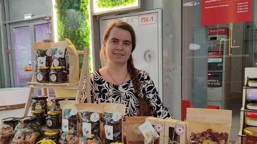 A person standing behind a counter with various food items