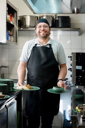 Osman mit den fertigen türkischen Gerichten in der Zamarod Küche.