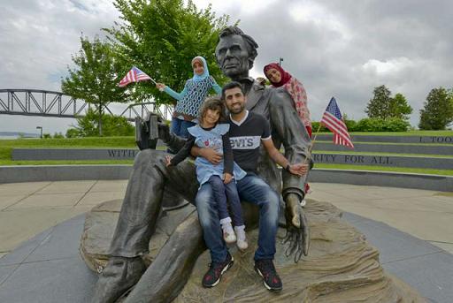 由伊拉克以来的阿拿巴家庭和他的三名女儿在美国肯塔基州的林肯总统像留影。© UNHCR/S.Rich