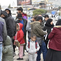 People gather outside at a border point.