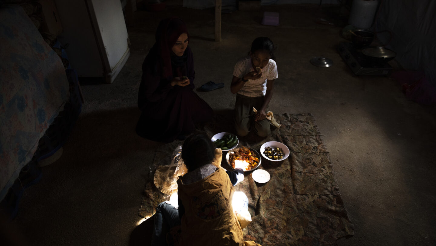 Eine syrische Flüchtlingsfamilie beim Essen in ihrer Unterkunft im Bekaa-Tal, Libanon